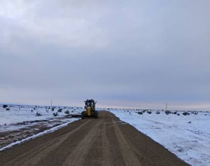 A tractor on a dirt road Description automatically generated